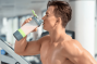 a fit young man drinking from his shaker bottle