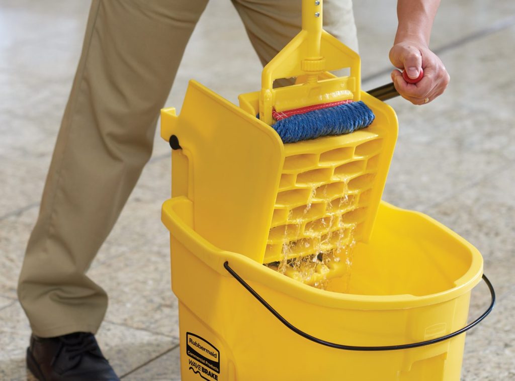 squeezing mop in a wringler mounted on a yellow bucket