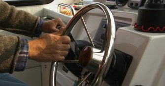 man using hydraulic steering wheel on the boat