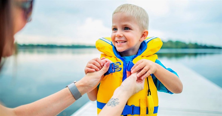 Mom putting his child the safety jacket