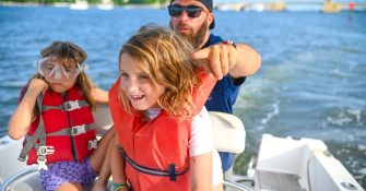 kids wearing life jackets on the boat