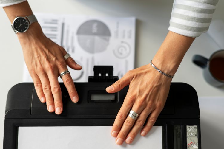 top view of a woman using a laser printer